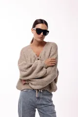 Saco tejido de punto color azul, con escote en V y cierre frontal mediante lazos. Presenta mangas largas amplias con puños ajustados y un calce relajado.