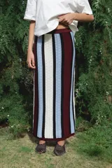 Falda larga tejida a rayas verticales en tonos azul, blanco, negro y bordó, con cintura elástica.