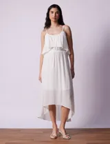 Vestido midi blanco de gasa bambula marca Lily Black, con escote redondo, breteles regulables y lazo de ajuste. Presenta una sobrecapa en el torso y un forro interno a tono. El largo de la espalda es mayor al largo delantero.