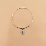 Brazalete tipo esclava de alambre redondo en plata 925, con medalla colgante circular que presenta el símbolo de la medicina en combinación de plata y oro 9k.