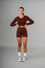 Conjunto deportivo color marrón chocolate, compuesto por remera crop top de manga larga y short ajustado.