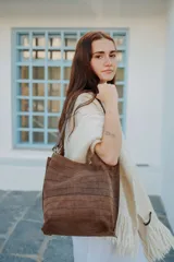 Cartera tipo bolso con diseño de animal print de leopardo, confeccionada en cuero. Presenta una correa de hombro fija con herrajes metálicos en tono bronce y un compartimento principal espacioso.