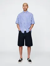 Short de jean de corte holgado y largo hasta la rodilla, en color azul oscuro con costuras en contraste.