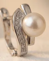 Caravanas de plata 925 con diseño de gota que incorpora una perla central y detalles de circonias engastadas.