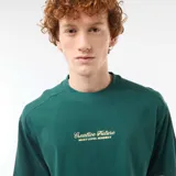 Remera verde oscuro de manga corta y corte holgado, con cuello redondo y delicado bordado frontal en contraste.