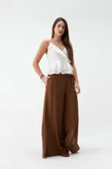 Pantalón marrón de corte ancho y fluido, con cintura elástica y bolsillos laterales, con aberturas en los laterales de las perneras.
