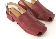 Sandalia de cuero color bordó con diseño de tiras anchas entrecruzadas, punta cuadrada y talón descubierto con pulsera ajustable. Cuenta con taco ancho medio forrado en cuero.