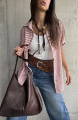 Camisa de manga corta con diseño a rayas rojas y blancas, cuello clásico y cierre frontal de botones.