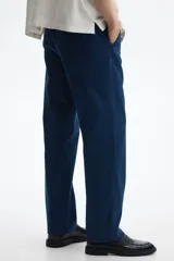 Pantalón de sarga de algodón en color azul marino, con corte relajado, cierre de cremallera y botón, bolsillos laterales al bies y bolsillos traseros insertados con botón.