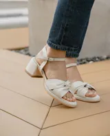 Sandalias de cuero color dorado, con plataforma y taco cuadrado. Presentan tiras cruzadas en el empeine y pulsera al tobillo con hebilla.