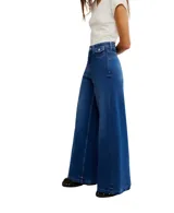 Jeans de mezclilla azul claro con corte palazzo extremadamente ancho y tiro alto. Presentan un efecto degradado o teñido que oscurece el color hacia los bajos de las piernas.