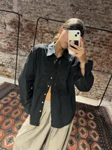 Camisa de algodón color negro, con detalles de bordado broderie en la parte frontal y en los hombros, de manga larga y corte clásico.