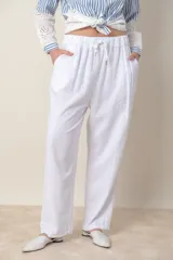 Pantalón blanco de lino, corte recto, con cintura elastizada con cordón y bolsillos laterales.