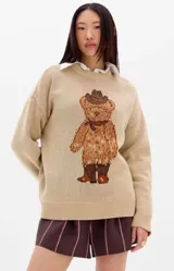 Sweater de punto color marrón claro, con diseño de oso estampado en el frente. Presenta cuello redondo, mangas largas con puños ajustados y corte holgado.