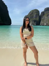 Vestido corto de playa tejido con diseño calado, sin mangas y cuello redondo. Presenta un calce adaptable al cuerpo.