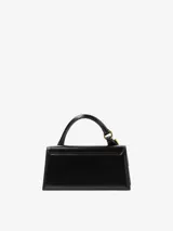 Bolso estructurado de cuero liso color negro, con asa superior reforzada, detalle de hebilla metálica dorada y logo de la marca en letras doradas en la parte frontal.