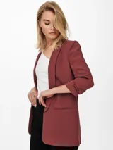Blazer regular fit color rosado viejo, con cuello solapa, mangas 3/4 y bolsillos frontales ribeteados.