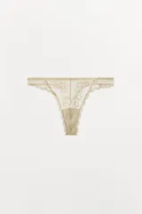 Tanga de tiro alto confeccionada en tejido mesh con detalles de encaje floral a tono y bordes festoneados.