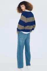 Jersey de punto a rayas horizontales azules y grises, con cuello tipo polo en color beige y cierre frontal con botones.