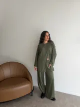 Conjunto de dos piezas color gris melange, confeccionado en tela de lanilla, compuesto por un buzo de manga larga con diseño cruzado al frente y un pantalón largo de corte holgado y tiro alto.