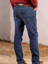 Pantalón de jean azul oscuro, corte recto, con cintura media y cierre con cremallera y botón.
