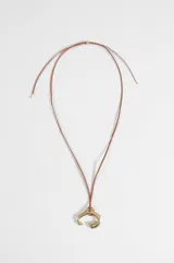 Collar de cordón marrón con dije metálico dorado de diseño curvo e irregular.