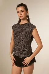 Musculosa de poliéster con estampado animal print, cuello buche y detalle de drapeado lateral que ajusta la prenda al cuerpo.