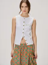 Musculosa MUTMA Trebola de silueta recta y tejido de punto blanco, con cierre frontal de botones y detalles de bordado verde en el pecho.