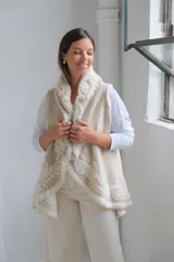Chaleco abierto de lana en color beige, con diseño de solapas amplias y bordados florales en relieve en tono crema. Posee un corte fluido y sin cierre frontal.