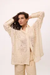 Camisa blanca oversize de algodón con cuello clásico, mangas largas y puños abotonados con detalle de tablas.