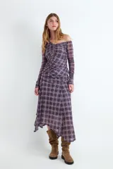 Top off-shoulder de manga larga con estampado de cuadros en tonos morados y beige. Confeccionado en tejido elástico y ligero, presenta un diseño fruncido en la parte frontal con cierre de botones.