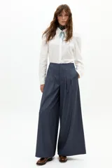 Pantalón culotte azul piedra, de tiro alto, con pinzas en la cintura y piernas anchas. Presenta sutiles rayas bordó y bolsillos laterales.