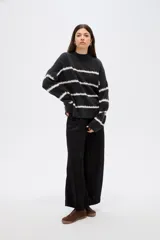 Sweater de punto con diseño de rayas horizontales en contraste, cuello alto y corte holgado con mangas largas.