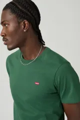 Remera de algodón de corte estándar y cuello redondo, color verde oscuro, con pequeño logo de la marca bordado en el pecho.
