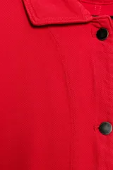 Chaqueta oversize de corte recto en color rojo, con cuello solapa, manga larga y bolsillos de parche delanteros. Cuenta con cierre frontal de botones metálicos y pespuntes a contraste.