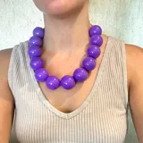 Collar de cuentas grandes de resina color violeta.