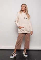 Canguro oversize color beige, de tela deportiva, con capucha ajustable con cordones y bolsillo tipo canguro en el frente.