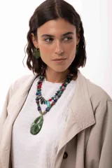 Collar corto de diseño artesanal compuesto por una variedad de cuentas de piedras naturales, cristales checos y acrílicos en tonos multicolor, incluyendo rojo, azul, turquesa y gris. Presenta un dije central en forma de gota color turquesa y cierre con cadena de acero quirúrgico ajustable.