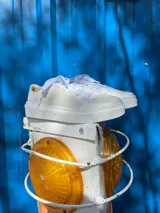Championes blancos de cuero liso, con cordones y suela plana.