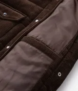 Campera puffer de Marfinno confeccionada en tejido de cotelé de algodón, con diseño acolchado, cuello inglés, cierre frontal con botones y dos bolsillos con solapa en el pecho.