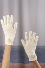 Par de guantes tejidos a mano en punto jersey, confeccionados en lana fina sin teñir con puño acanalado.