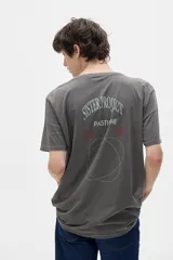 Remera gris de cuello redondo y manga corta, corte oversized, con estampado en el frente y la espalda con texto y figuras geométricas.