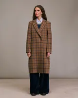 Tapado largo marrón con diseño a cuadros azules, solapas de pico, mangas largas con abertura y botones, bolsillos frontales con tapa y forro interior.