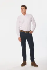 Pantalón de vestir azul marino, de corte recto, con bolsillos laterales y traseros. Se ajusta a la cintura con cinturón de cuero marrón.