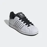 Championes Adidas Superstar blancos con detalles en negro, incluyendo las tres tiras laterales y el contrafuerte. Presentan la puntera de goma característica y cordones negros.