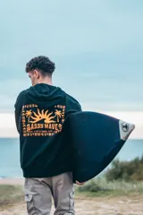 Hoodie oversize negro con capucha y estampado en la espalda con diseño inspirado en surf y olas en tono naranja.