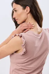 Remera lisa de algodón color beige, sin mangas, con detalles de volados en los hombros y cuello redondo.