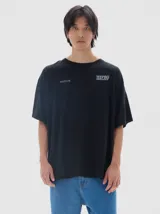 Remera unisex de corte oversized, color negro, con cuello redondo y mangas cortas. Presenta estampados minimalistas en el pecho.