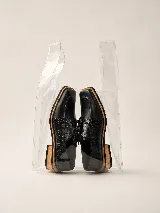 Zapato acordonado de cuero vacuno con textura de reptil en los laterales y puntera cuadrada. Presenta una suela de madera con base de goma y tacón bajo.