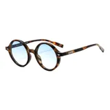 Lentes de sol circulares con marco carey en tonos marrones y beige, y cristales degradados en tono celeste.